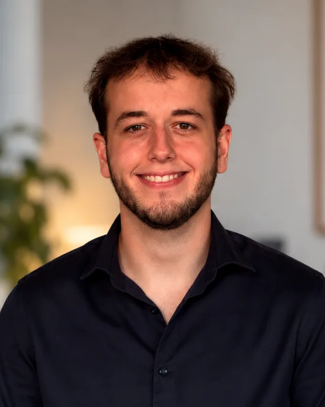 Paul-André Bossart, souriant, en chemise sombre, dans une pièce claire.